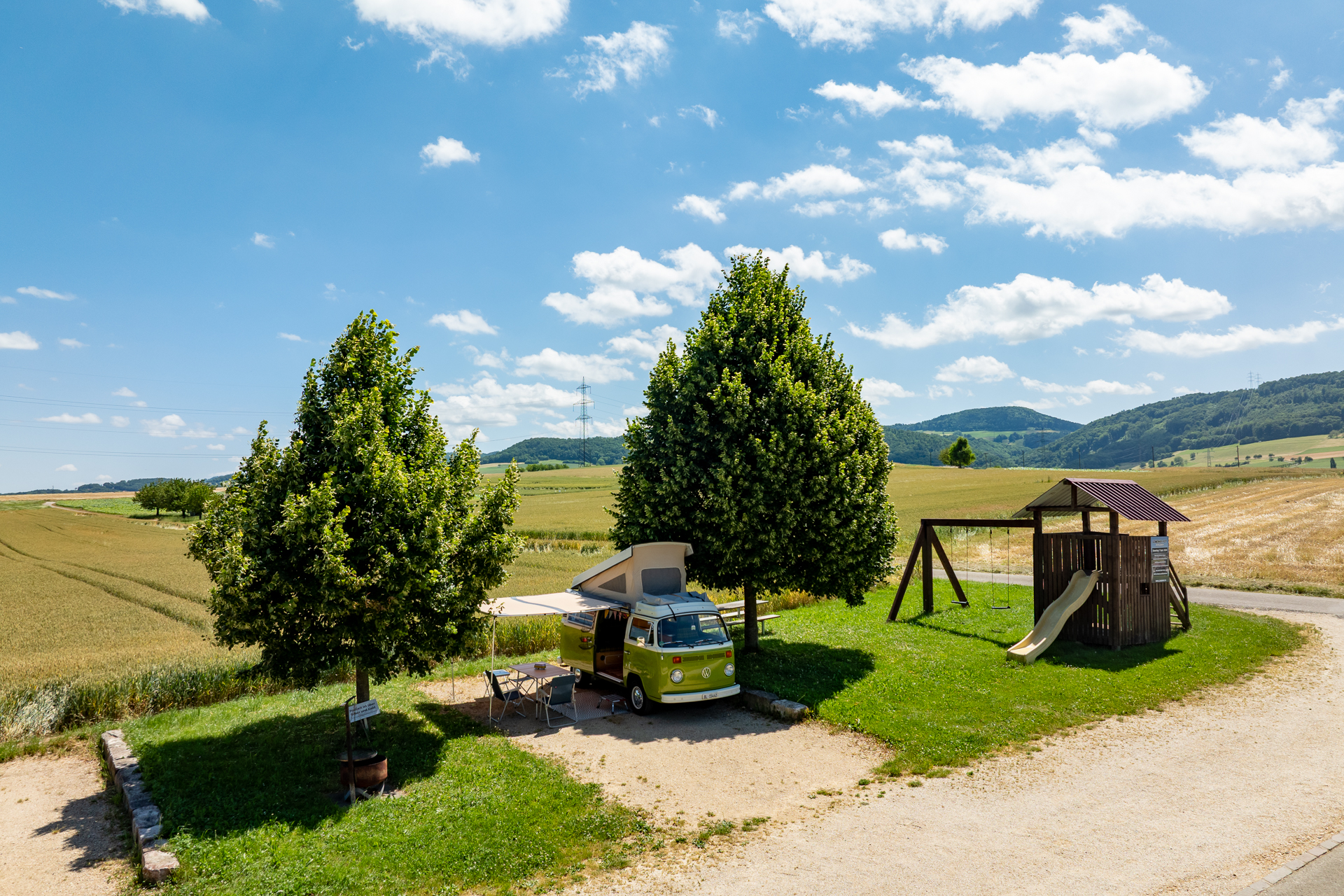 Stellplatz mit Wohnmobil und Spielplatz, Blick über Felder im Baselbiet